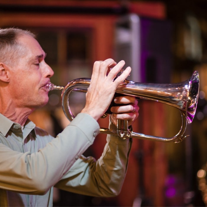 Jon on trumpet under stage lights